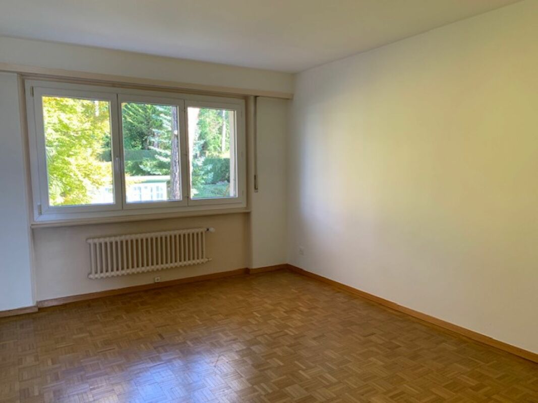 Helles, leeres Schlafzimmer mit Fenster und Heizkörper