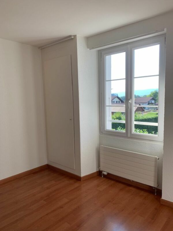 Leerer heller Raum mit Fenster und Einbauschrank