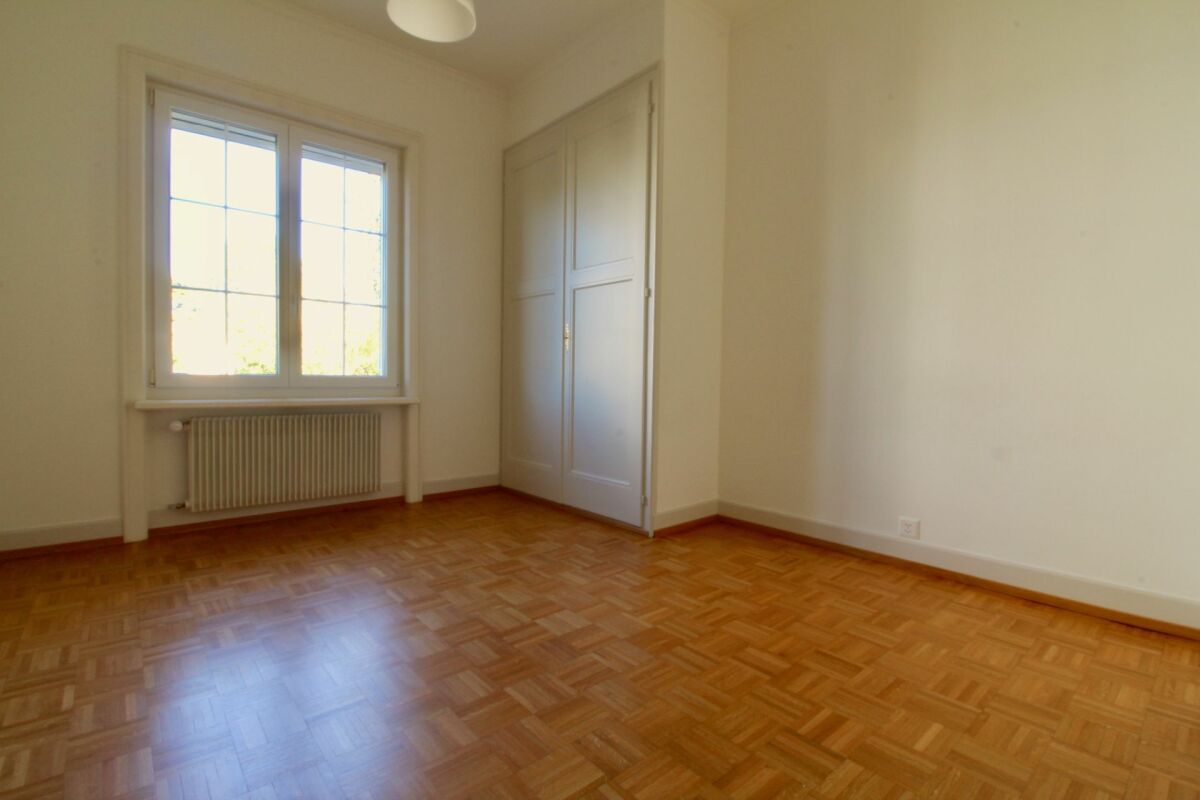 Leerer, heller Raum mit Parkett und Fenster