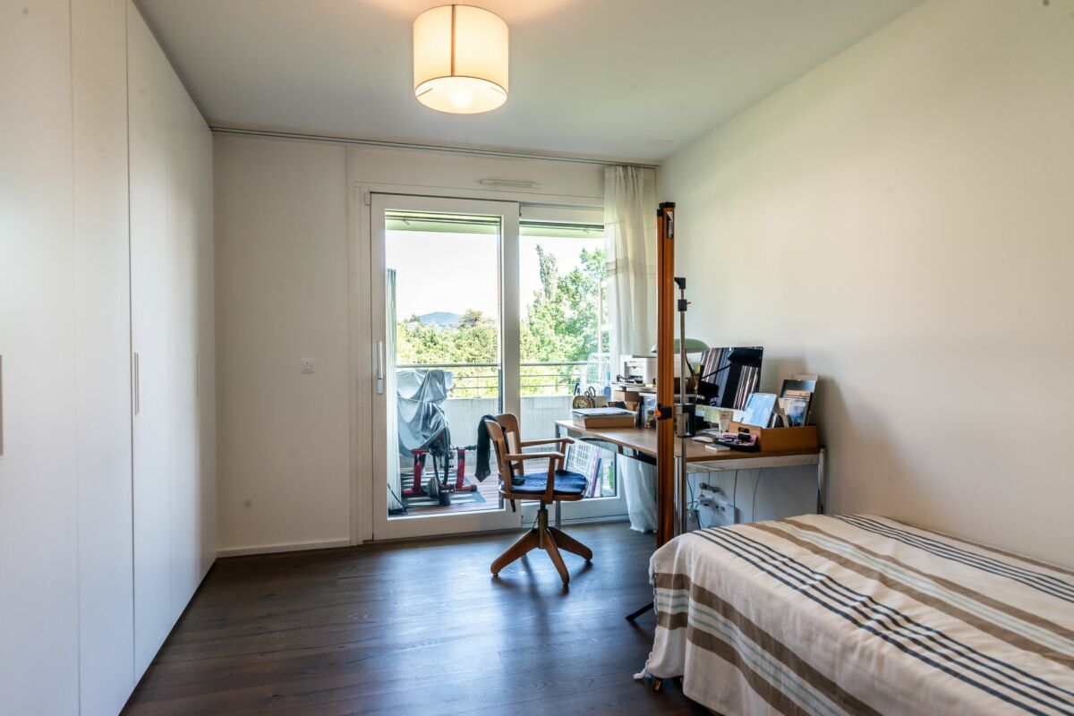 Helles Schlafzimmer mit Arbeitsplatz und Balkonzugang