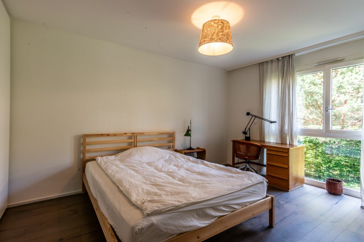 Helles Schlafzimmer mit Holzmöbeln und Gartenblick