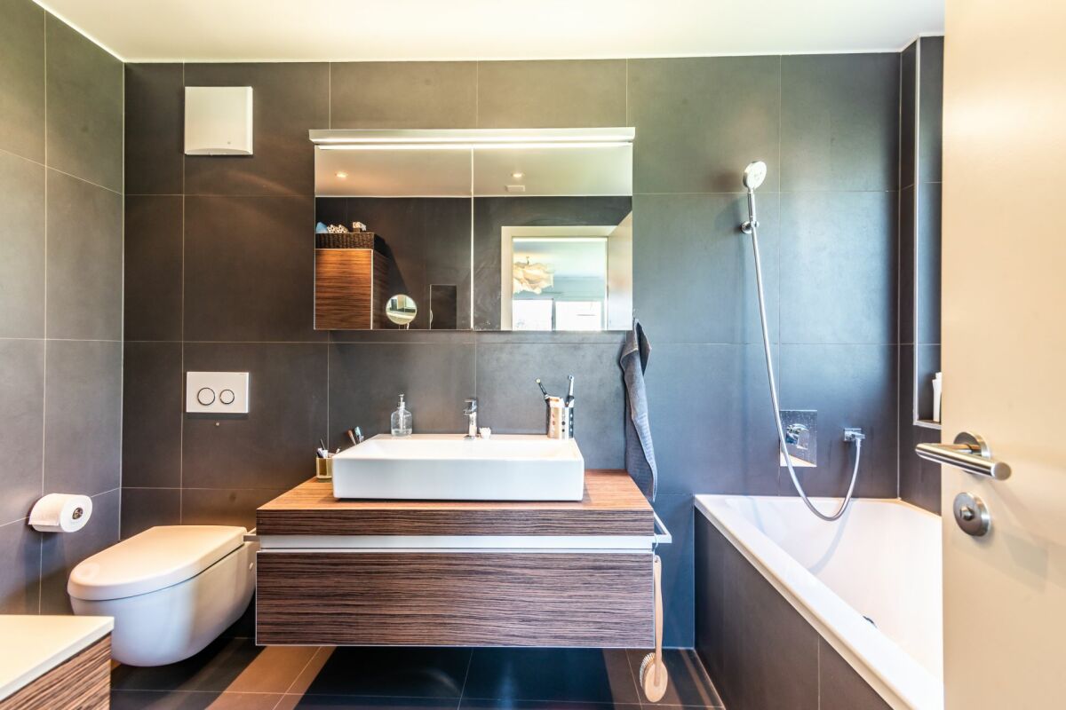 Modernes Badezimmer mit dunklen Fliesen und Holzoptik
