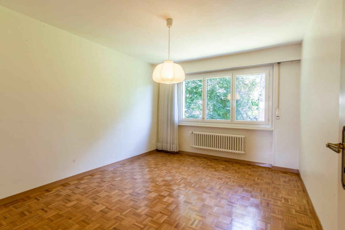 Leerer Wohnraum mit Parkett, Fenster und Heizkörper