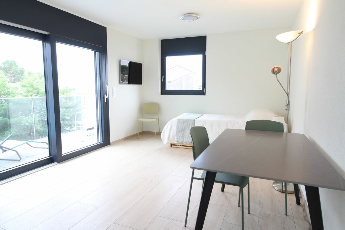 Helles Wohn- und Schlafzimmer mit Balkonzugang