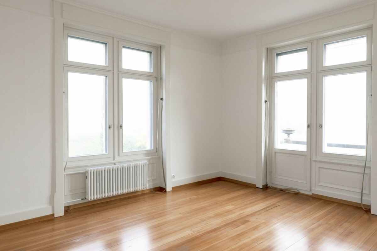 Heller leerer Wohnraum mit großen Fenstern