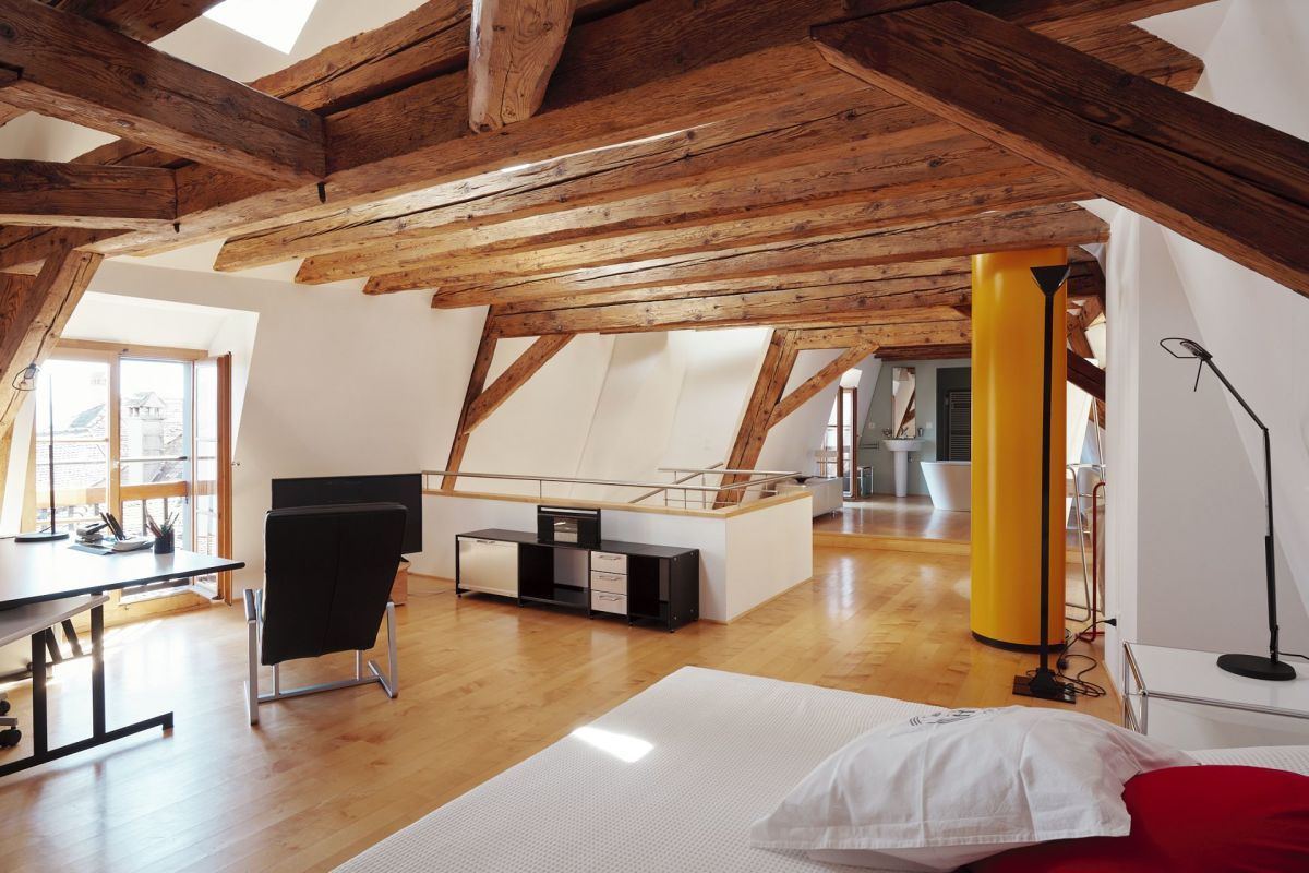 Offener Dachgeschossraum mit sichtbaren Holzbalken