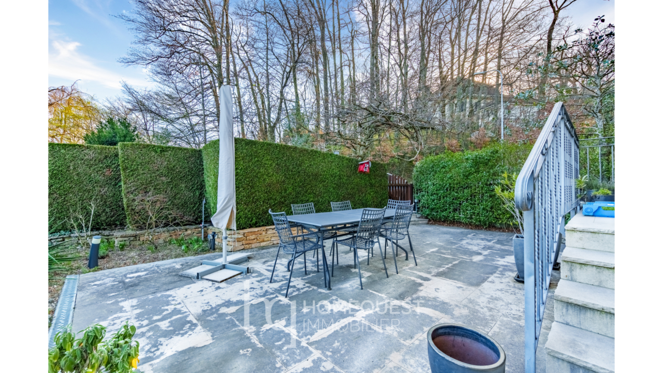 Terrasse mit Esstisch und Heckenbegrünung