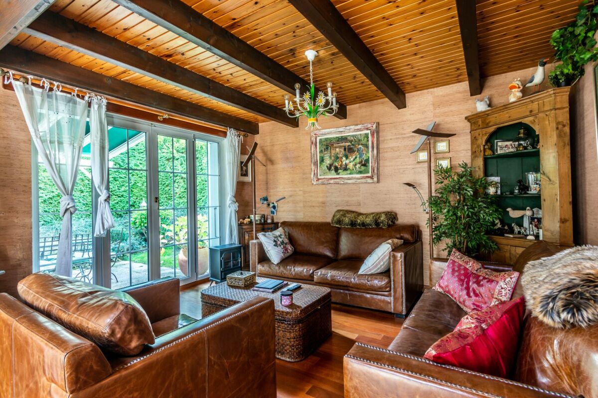 Gemütliches Wohnzimmer mit Holzdecke und Schiebetür zum Garten