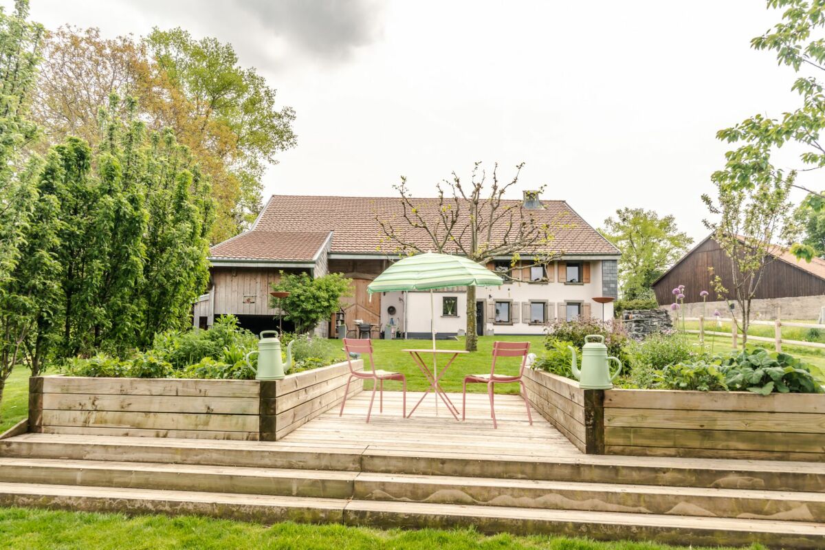 Ländlicher Garten mit Terrasse vor einem Bauernhaus
