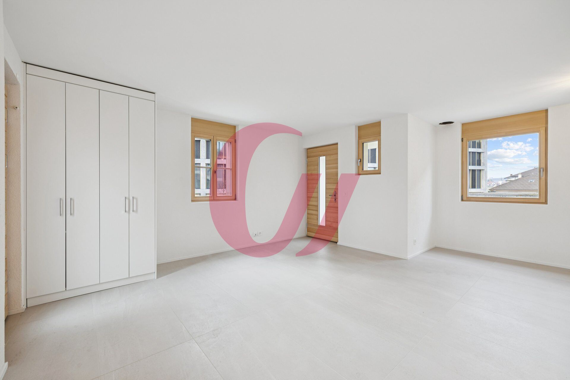 Helles, leer stehendes Zimmer mit Einbauschrank und Holztür