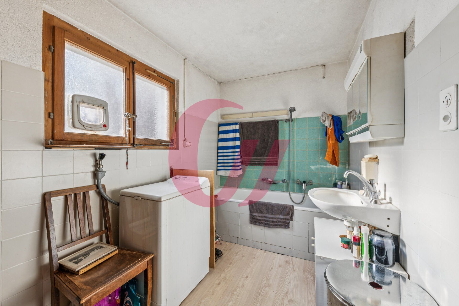 Ein kleines, schlichtes Badezimmer mit Badewanne und Fenster.