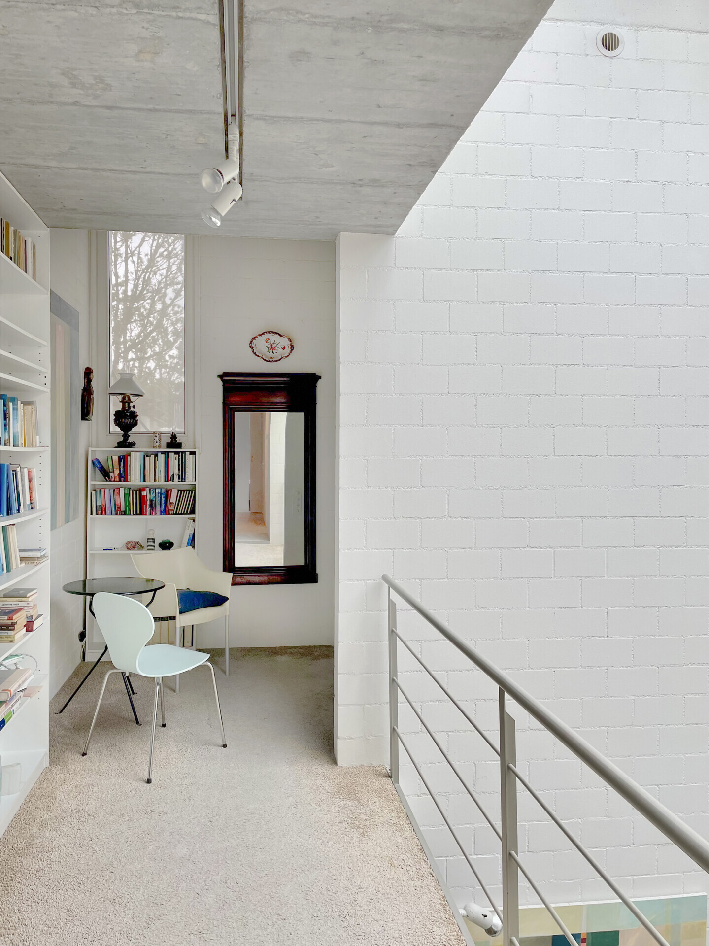 Helle Galerie mit Bücherregalen und Treppe
