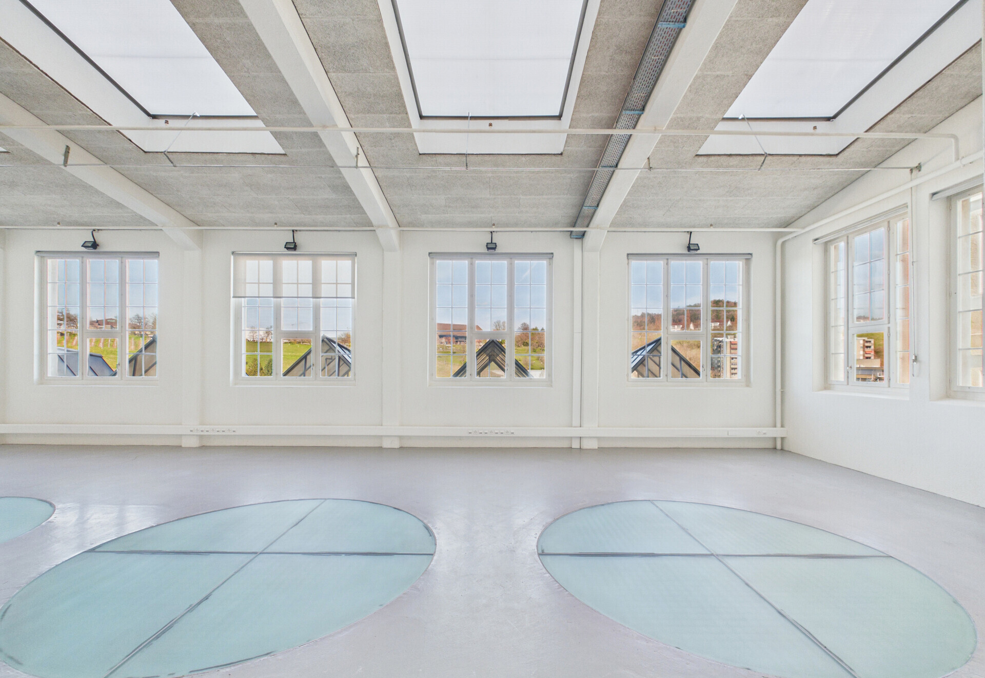 Lichtdurchfluteter, leerer Loft-Raum mit großen Fenstern