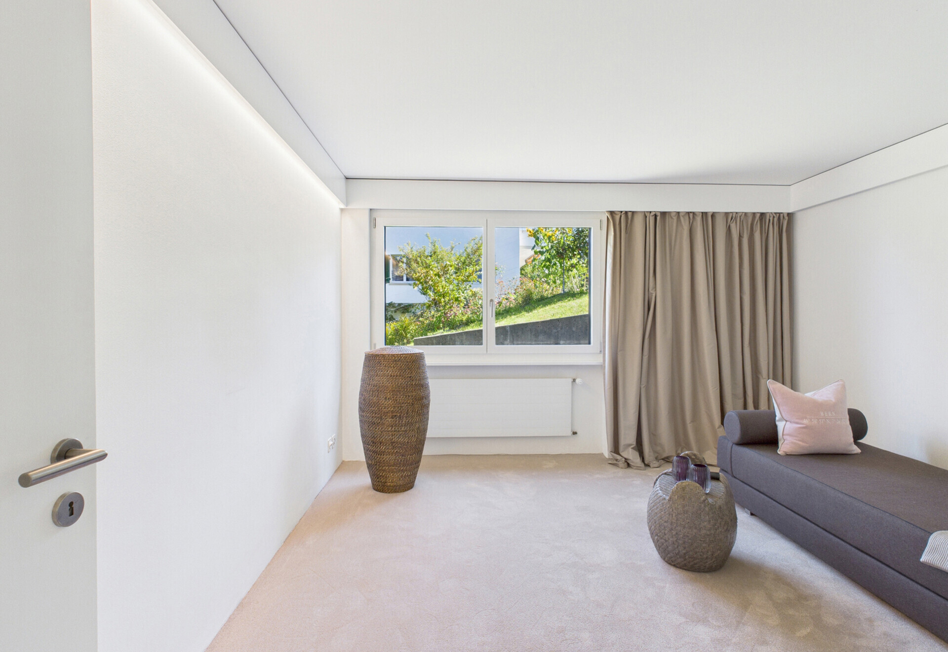Helles, minimalistisches Schlafzimmer mit Blick ins Grüne