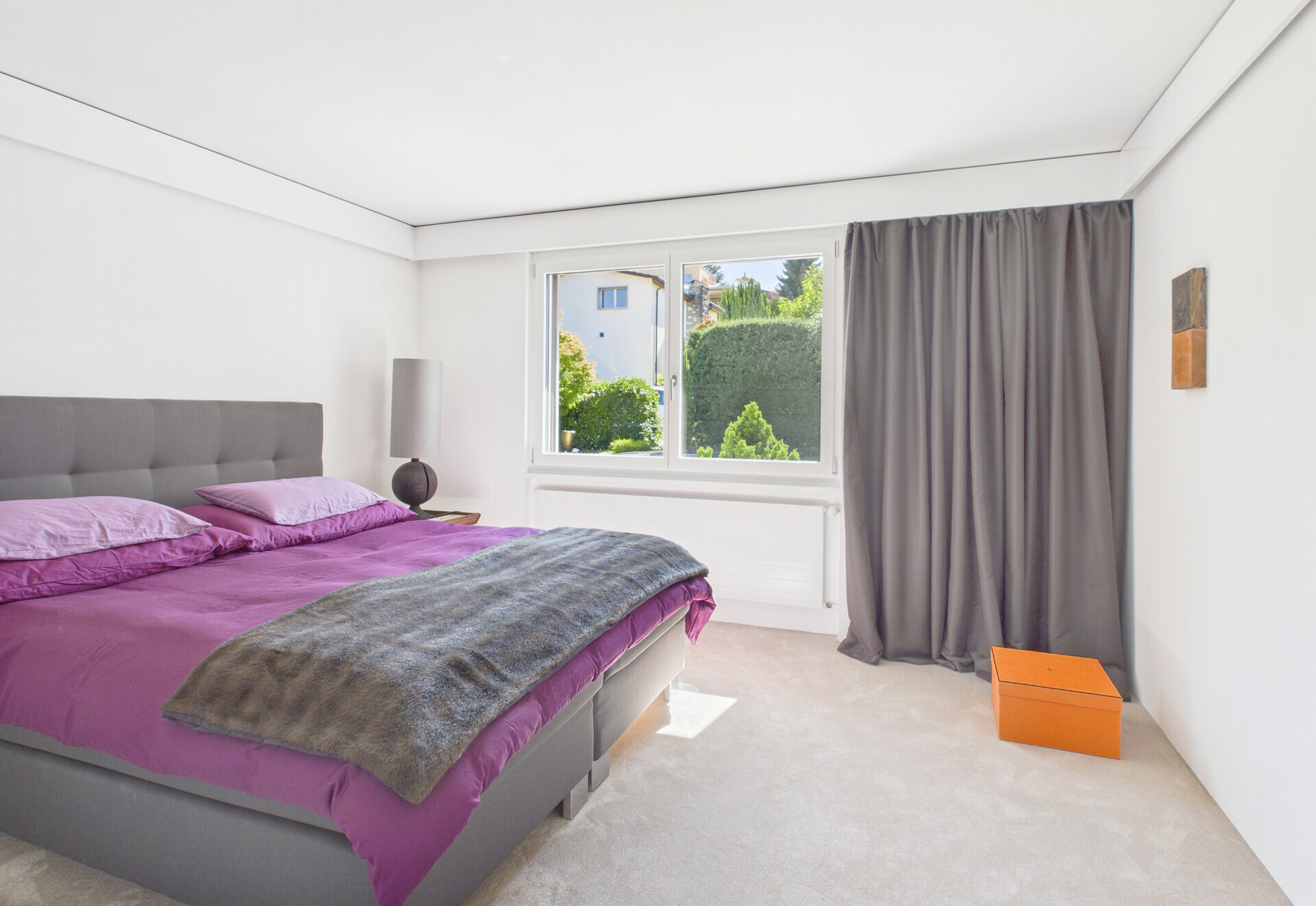 Helles Schlafzimmer mit Doppelbett und Fensterblick