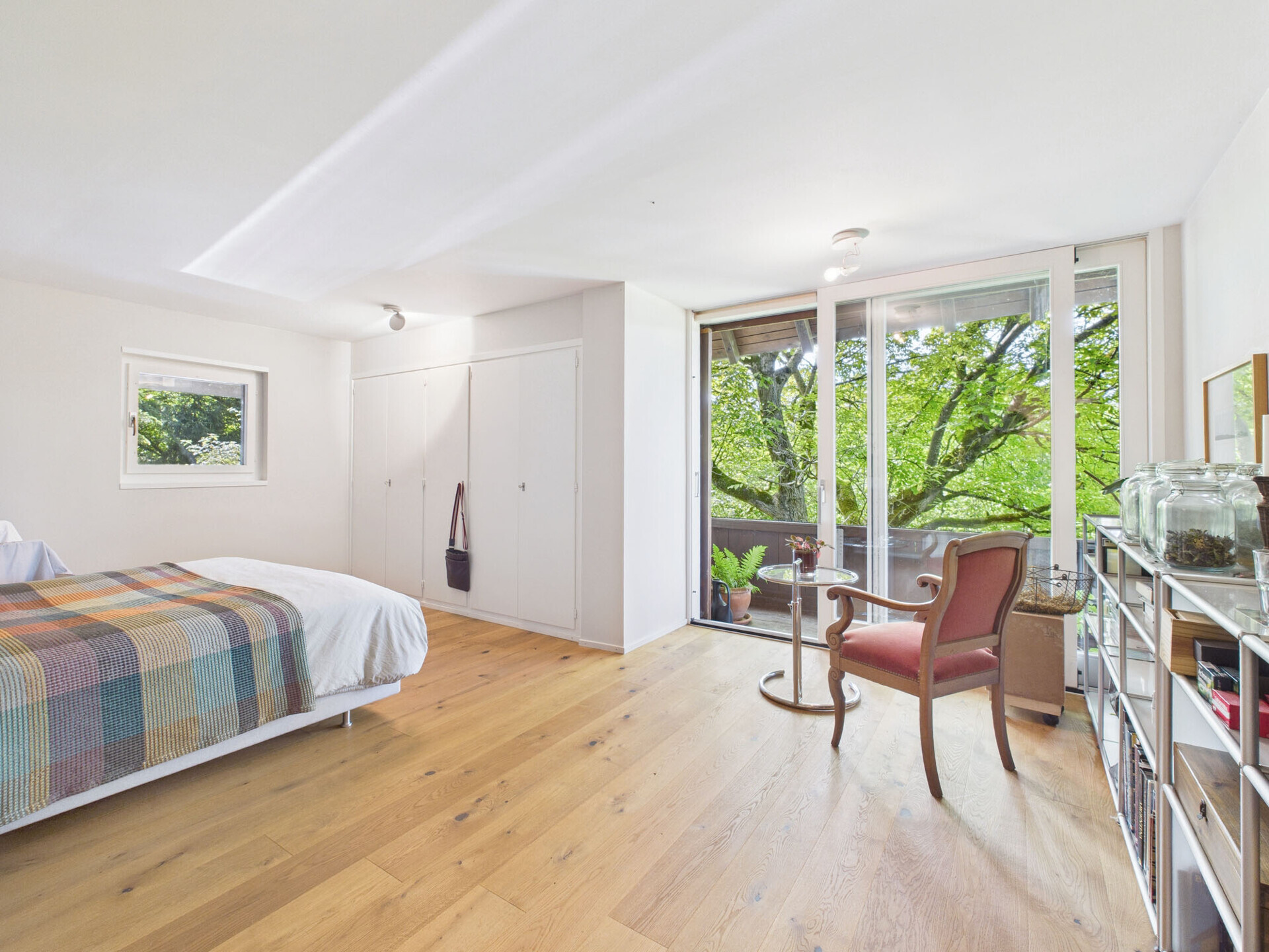 Helles Schlafzimmer mit Balkon und Gartenblick