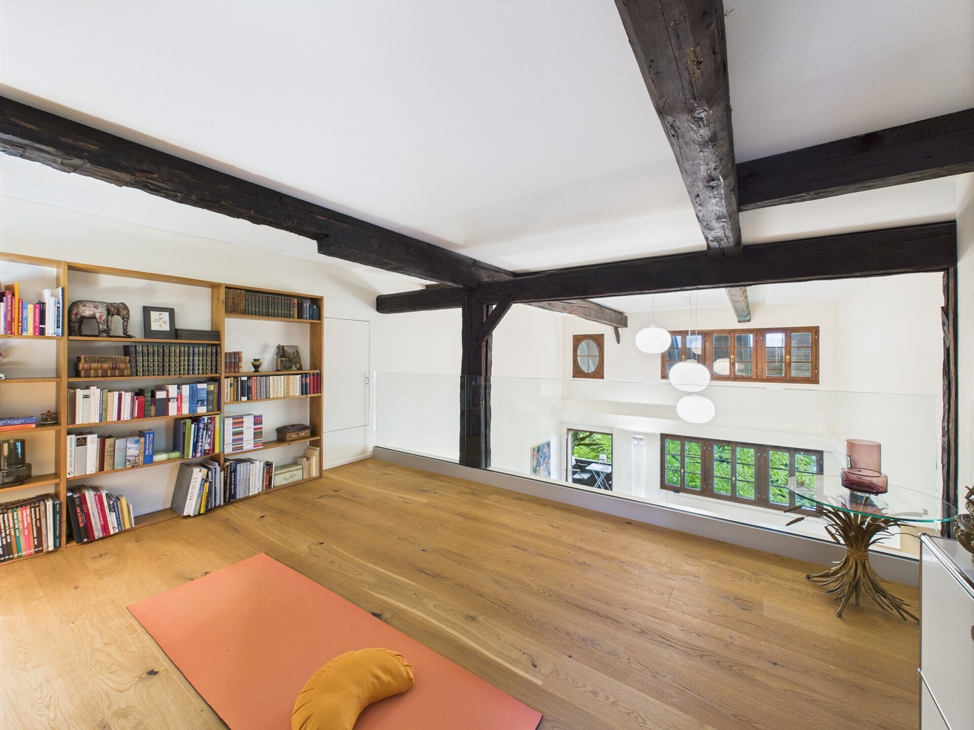 Galerie mit Holzbalken und Bücherregal