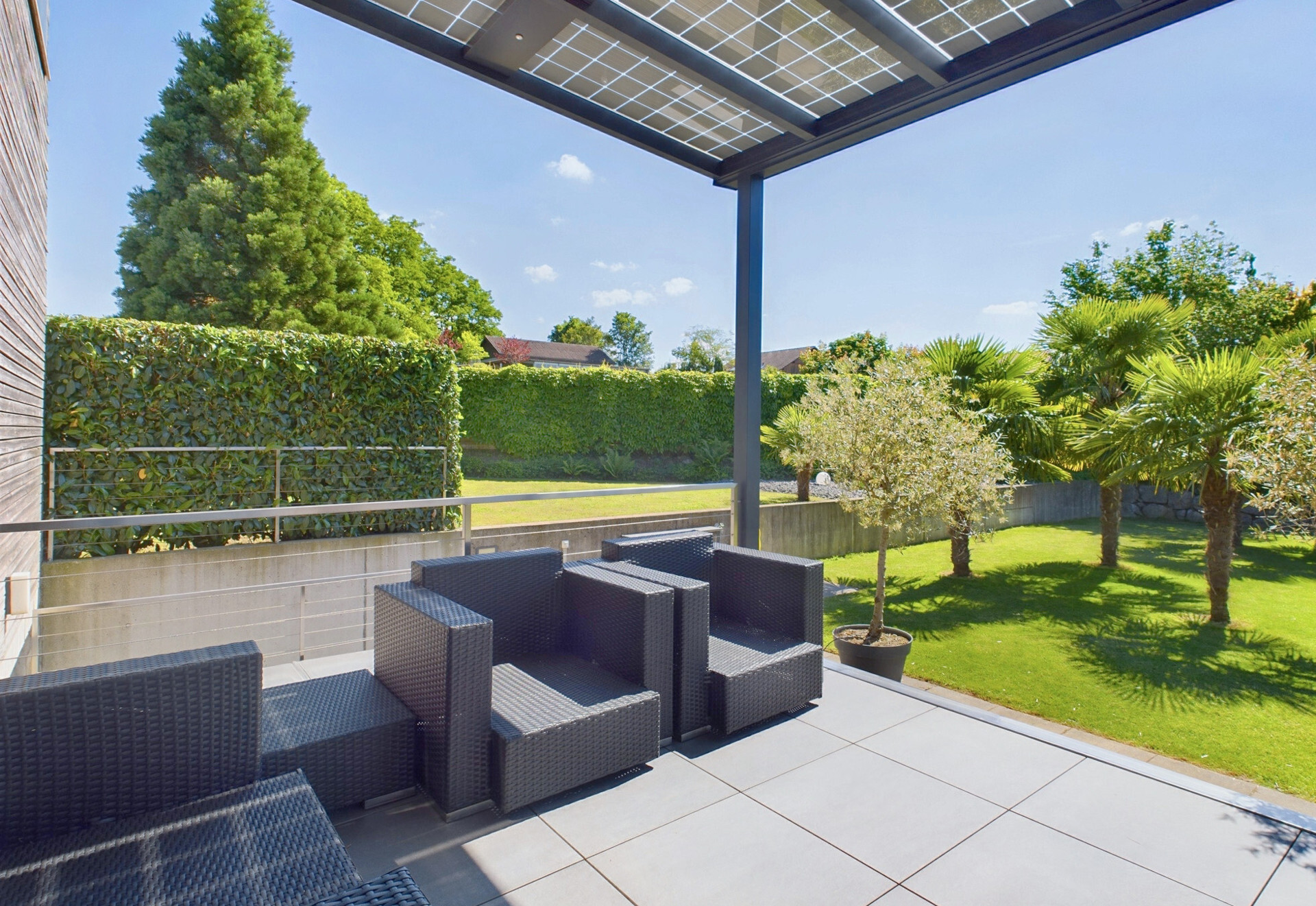 Überdachte Terrasse mit Gartenblick