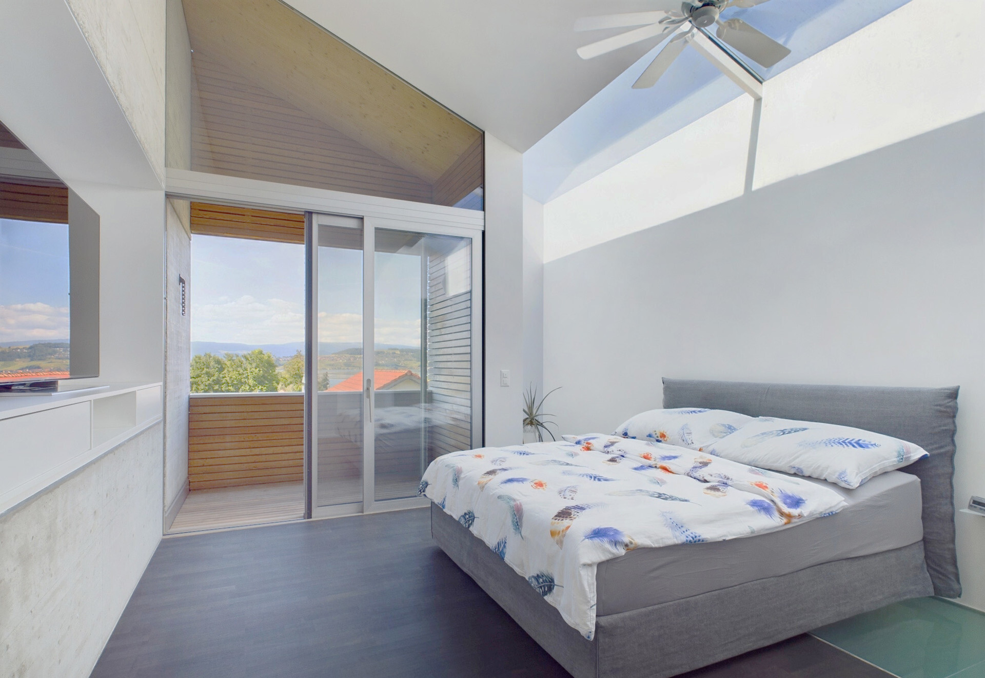 Modernes Schlafzimmer mit hoher Decke und Balkonblick