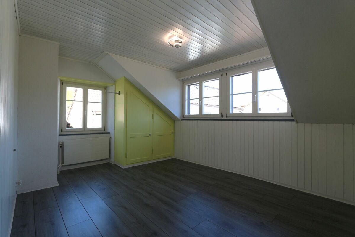 Dachgeschosszimmer mit schrägen Wänden und Einbauschrank