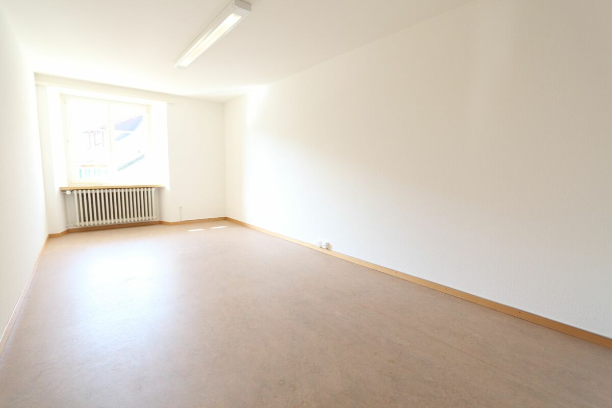 Leerer heller Raum mit Fenster und Heizkörper