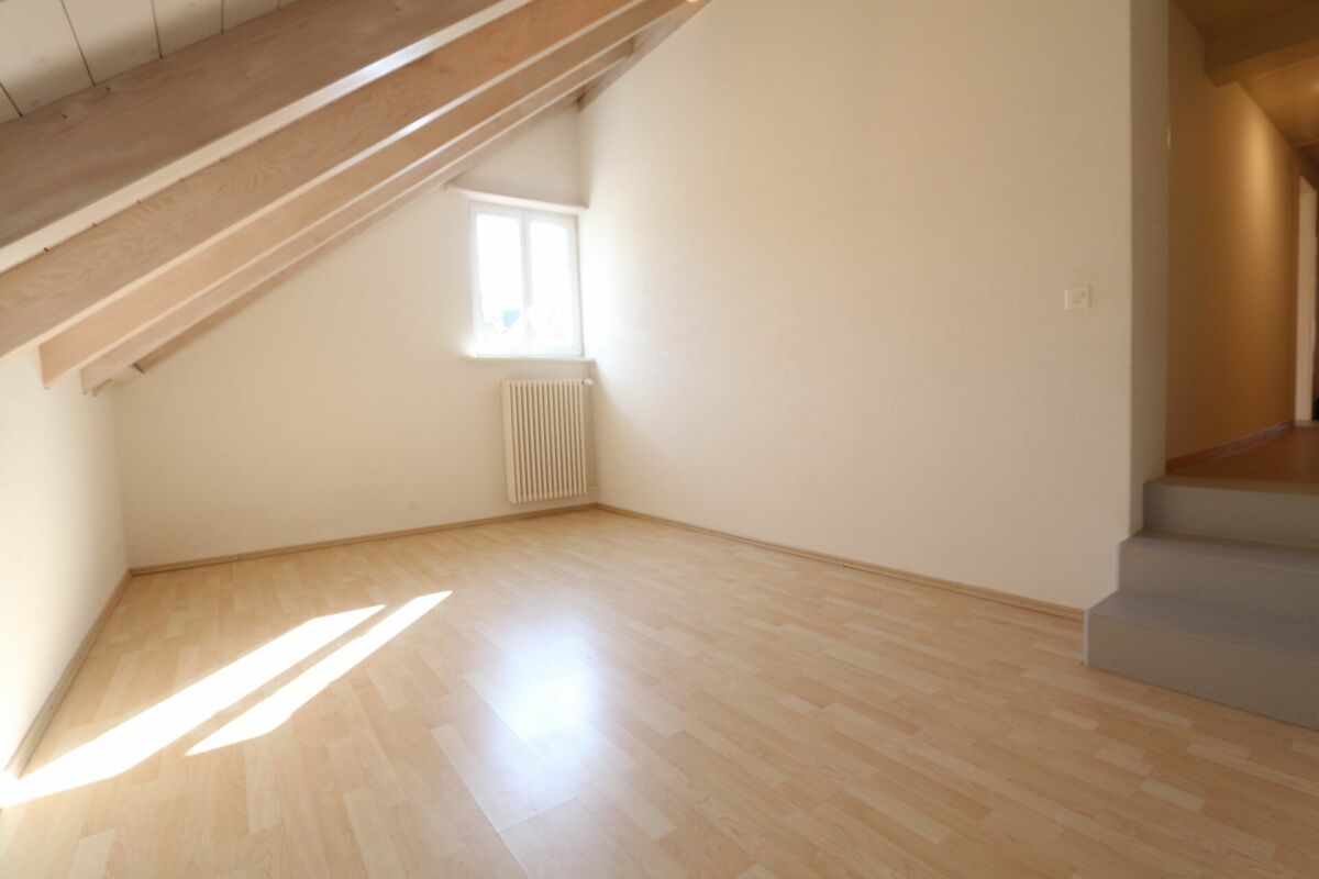 Dachgeschossraum mit Dachschräge und Fenster