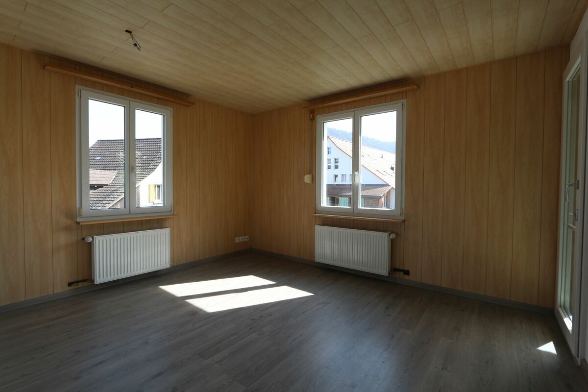 Leerer Raum mit Holzverkleidung und großen Fenstern