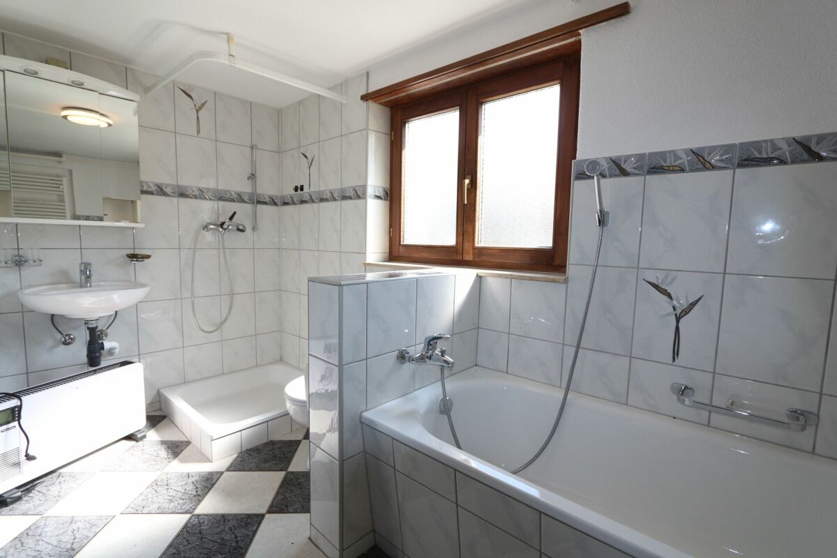 Badezimmer mit Badewanne und Dusche