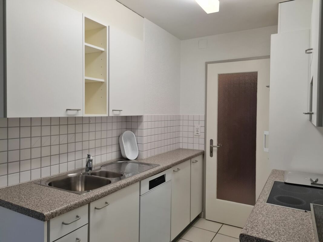 Kleine helle Küche mit weißen Fronten
