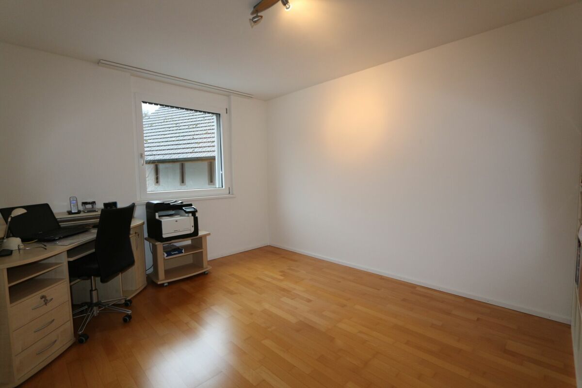 Büro- oder Arbeitszimmer mit Schreibtisch und Laminatboden