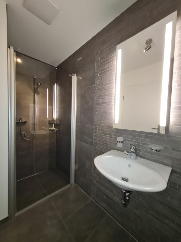 Modernes Badezimmer mit begehbarer Dusche und Wandwaschbecken