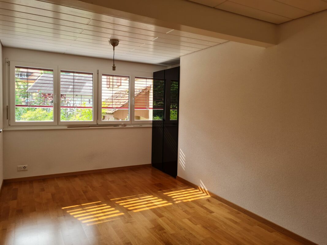 Helles leeres Zimmer mit Holzfußboden