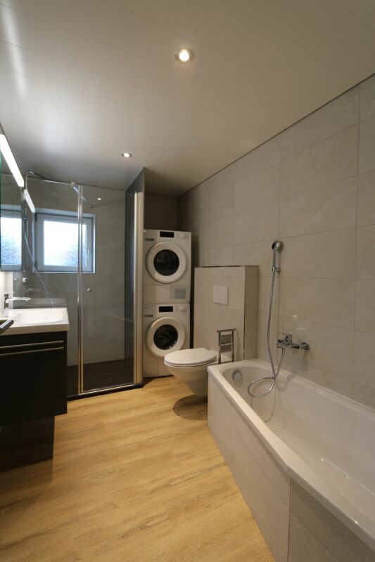 Modernes Badezimmer mit Badewanne und Waschturm