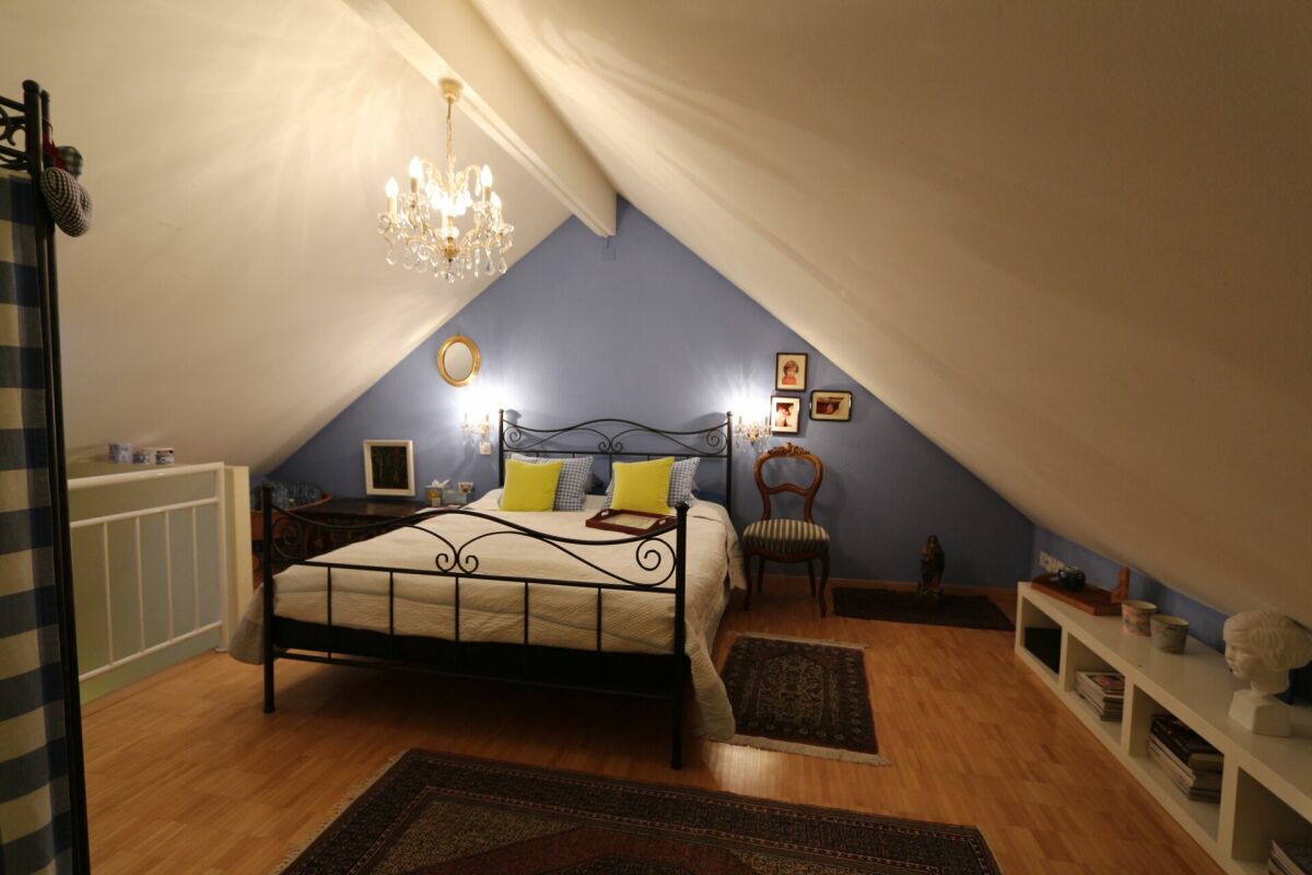 Dachgeschoss-Schlafzimmer mit Bett und Teppich