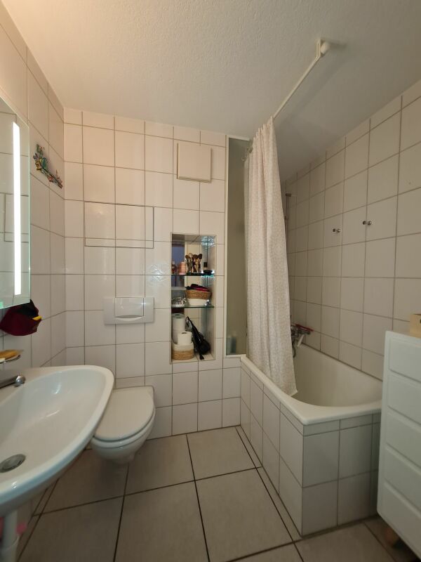 Kleines Badezimmer mit Badewanne und WC