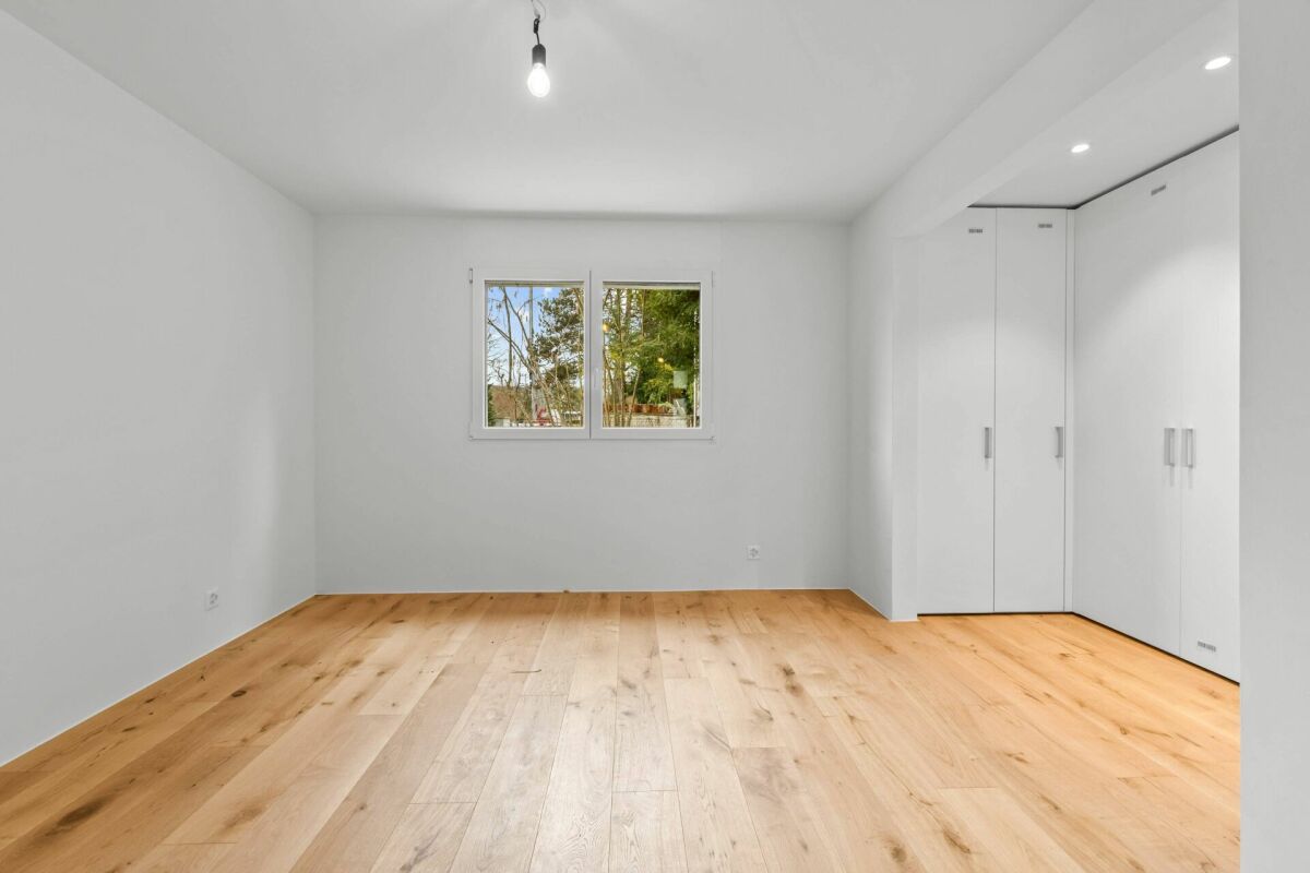 Heller leerer Raum mit Holzfußboden und Einbauschränken