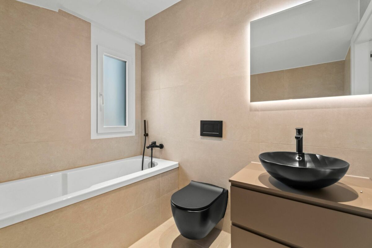 Modernes Bad mit Wanne und schwarzem Waschtisch