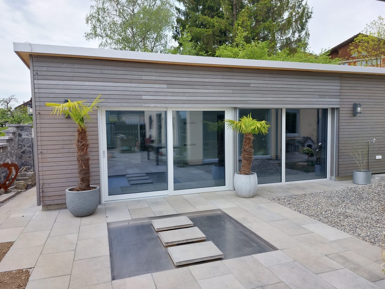 Moderne Holzfassade mit großer Schiebetür und Terrasse