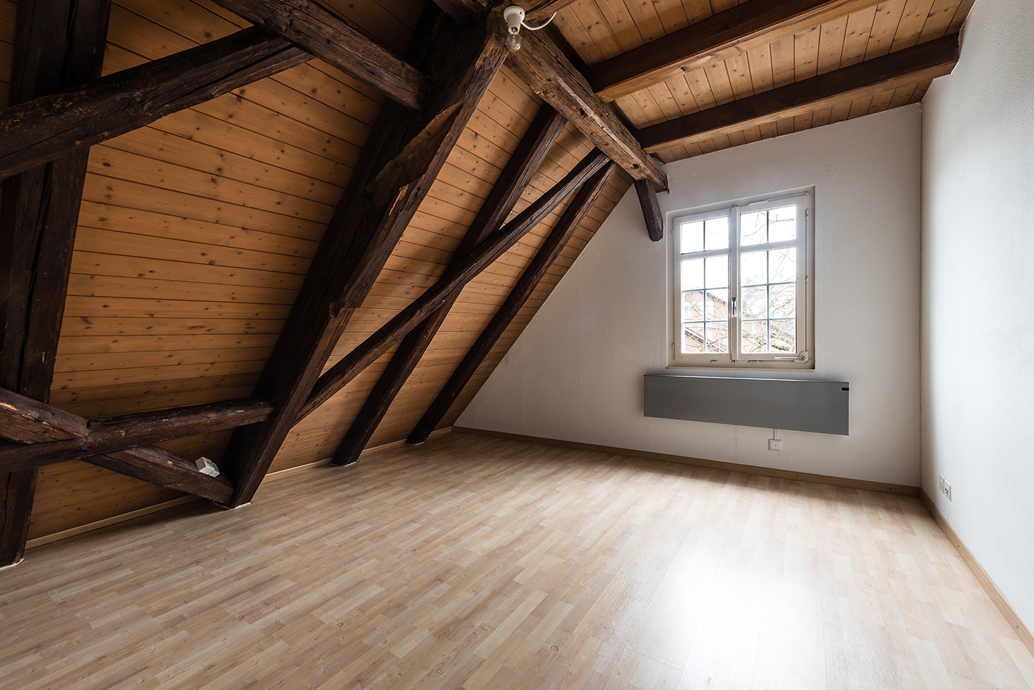 Dachgeschossraum mit sichtbaren Holzbalken