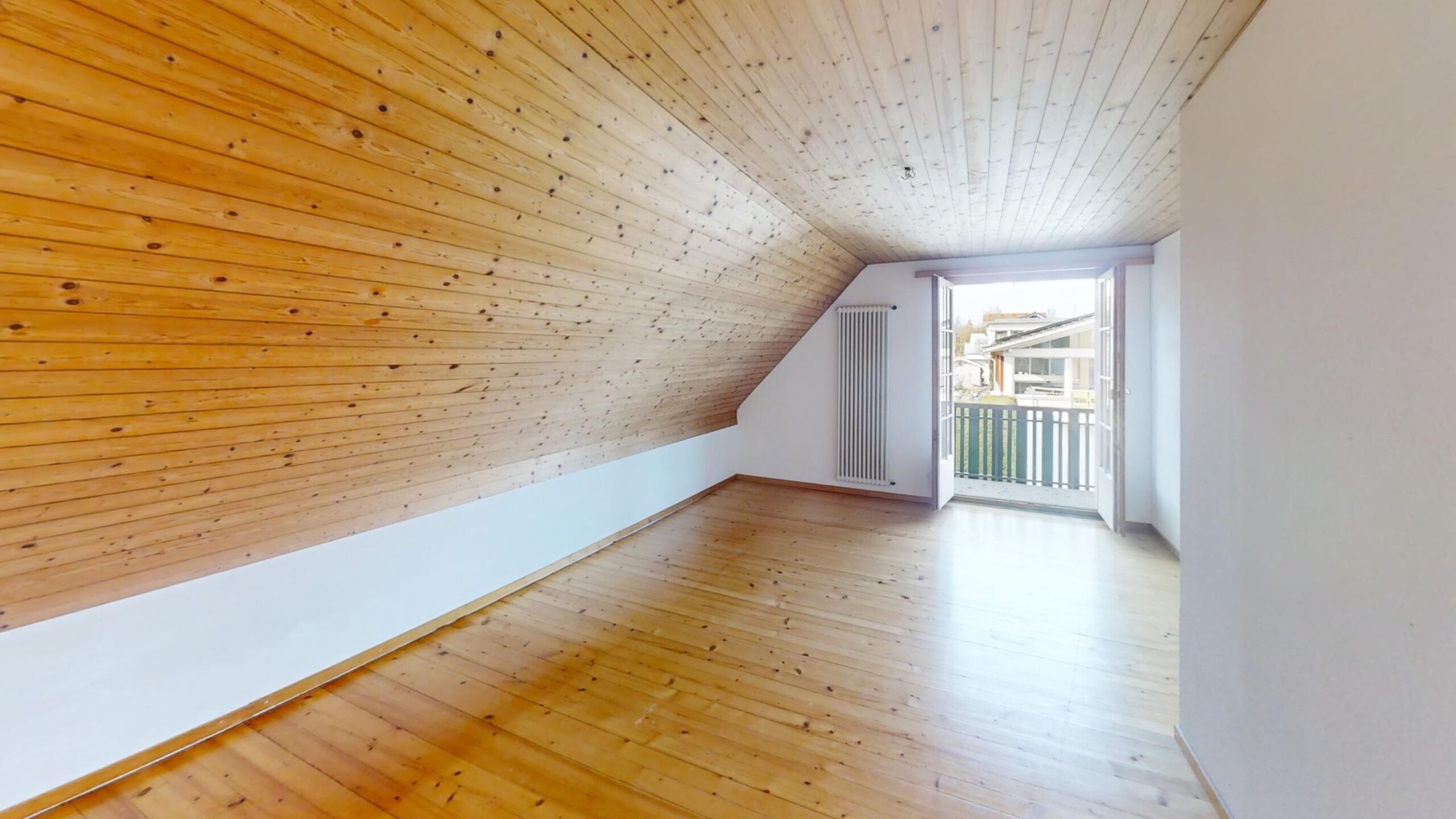 Dachgeschosszimmer mit Holzbalkendecke und Balkon