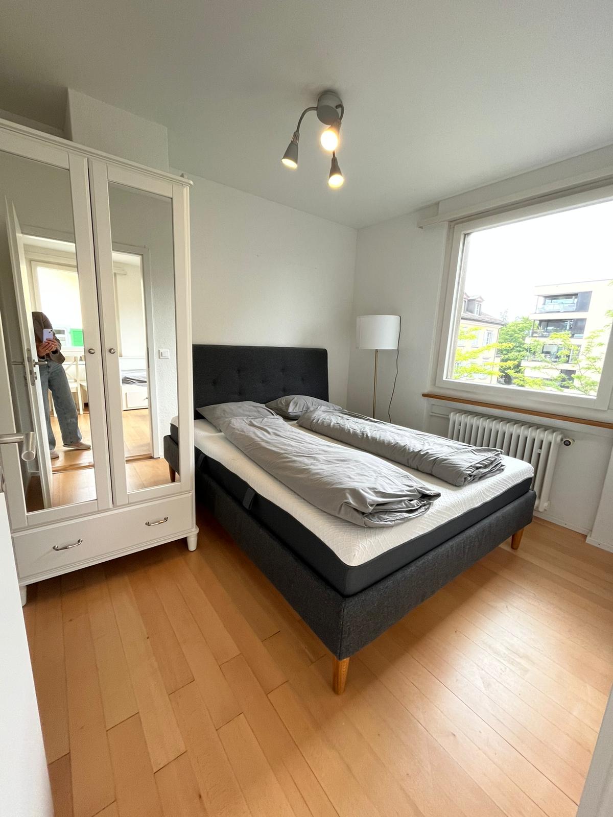 Helles Schlafzimmer mit Doppelbett und Kleiderschrank