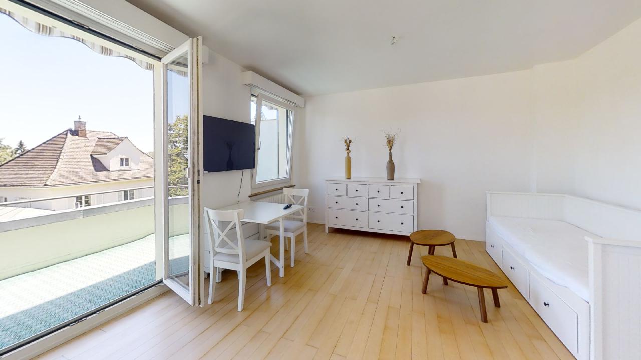 Heller Wohnraum mit Balkon und minimalistischer Möblierung
