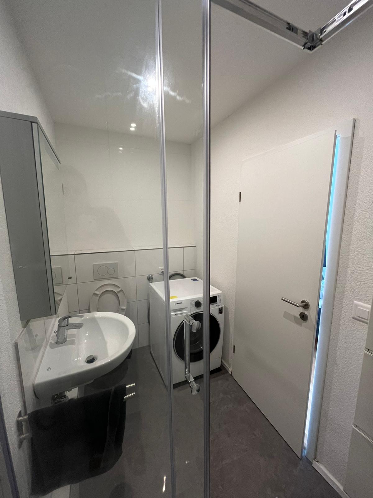Kleiner Hauswirtschaftsraum mit Waschbecken und Waschmaschine
