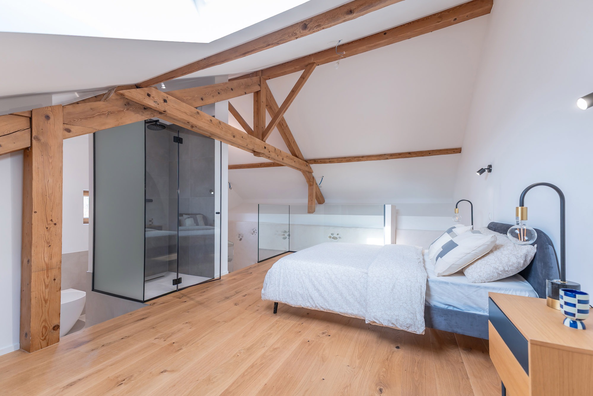 Helles Dachgeschoss-Schlafzimmer mit sichtbaren Holzbalken