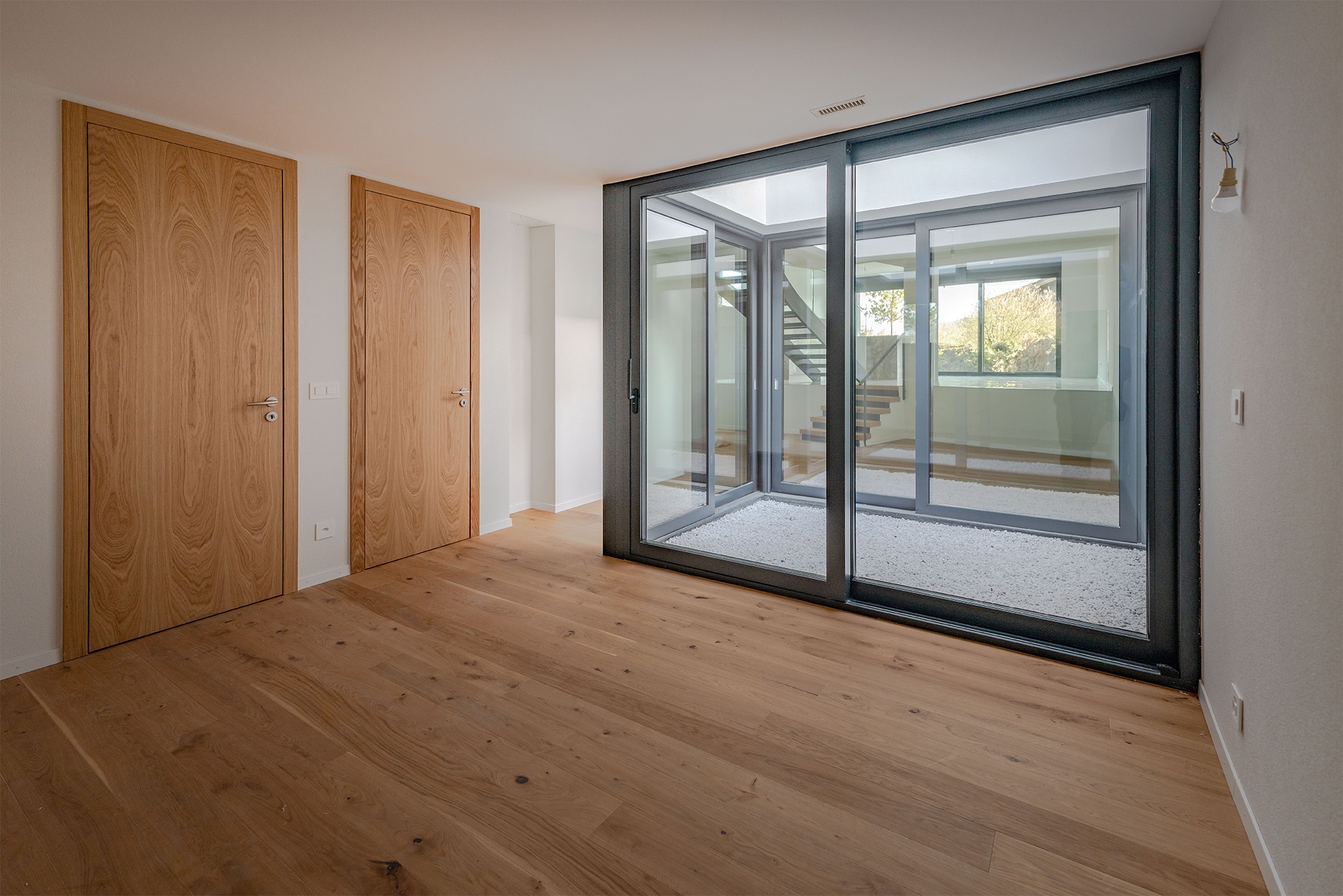 Helles Zimmer mit Holzboden und Innenhofblick