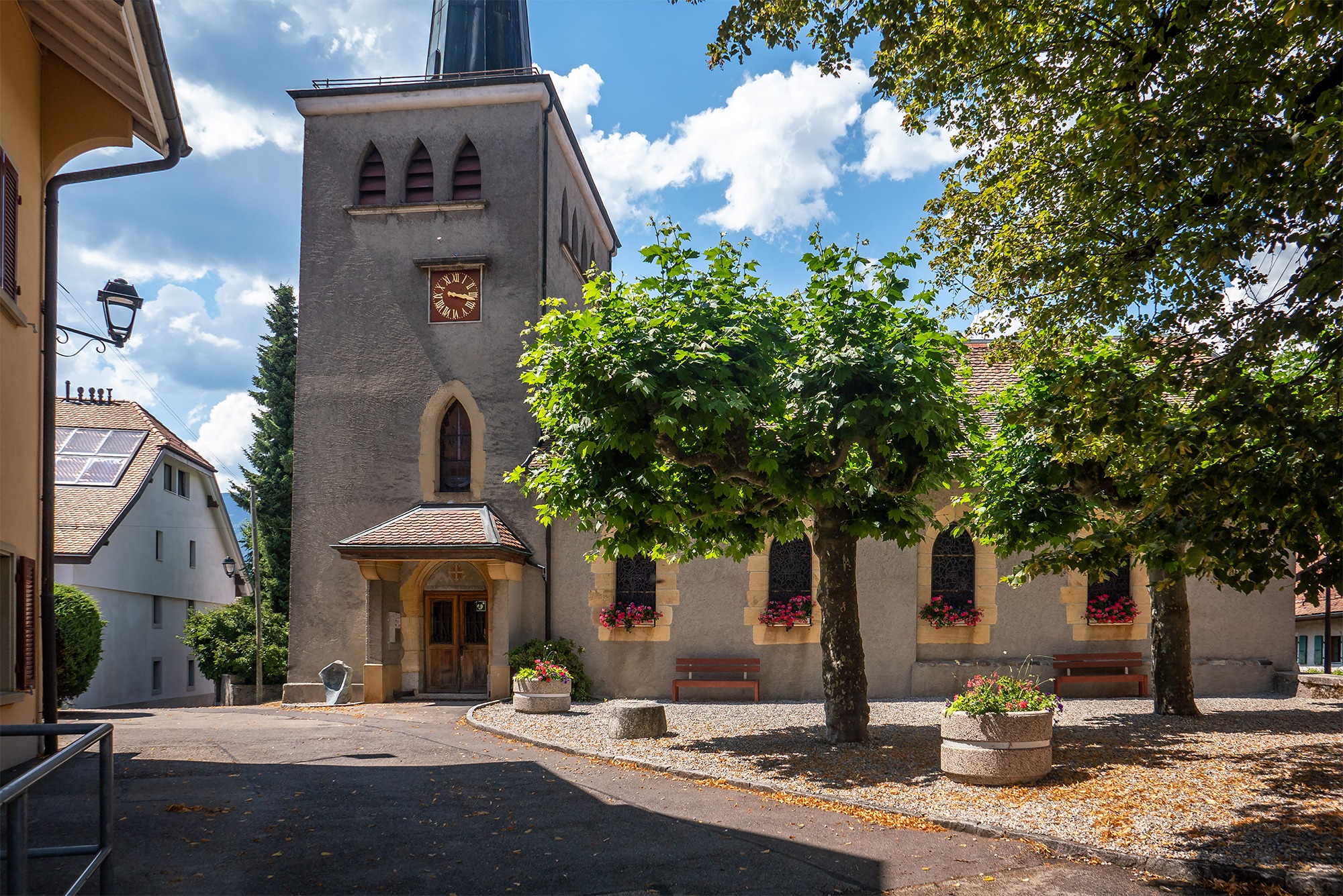 Kirchengebäude mit Turm und Vorplatz