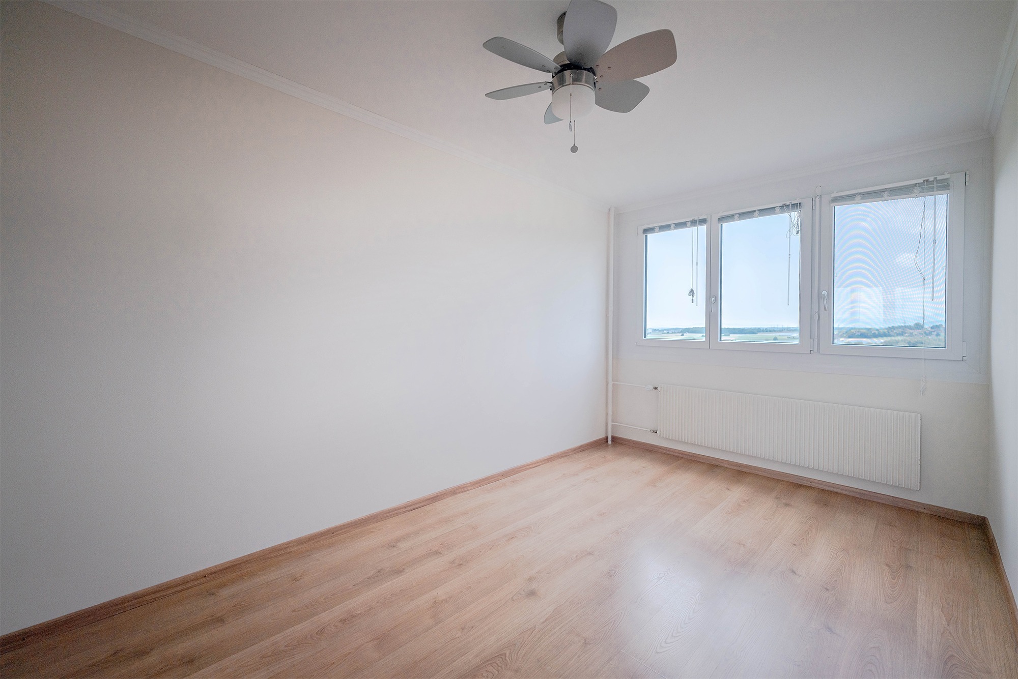 Helles, leeres Schlafzimmer mit Blick ins Freie