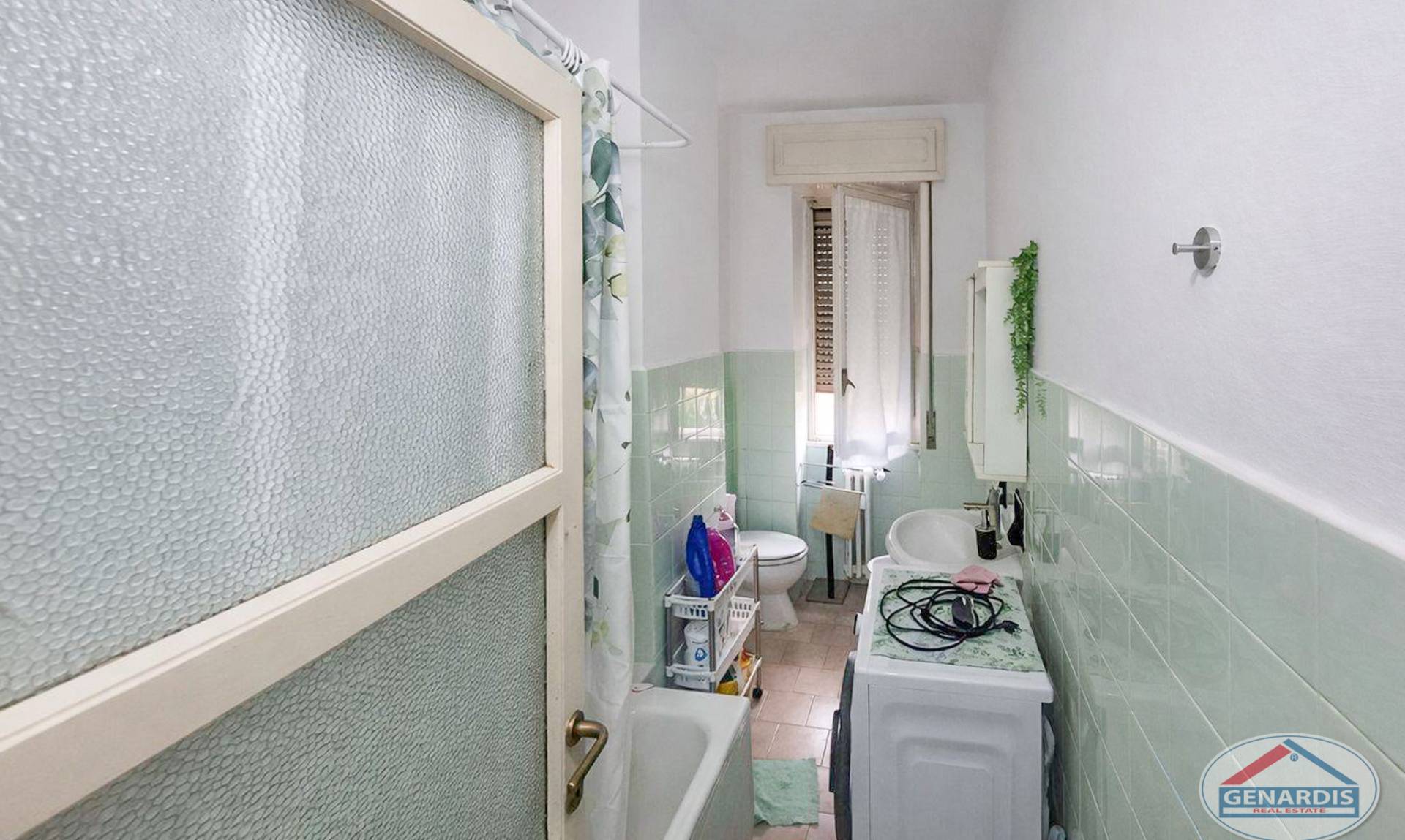 Langes Badezimmer mit Schrägdach und Milchglas-Trennwand