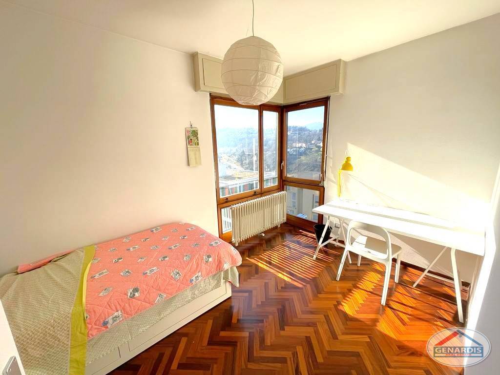 Helles Schlafzimmer mit Eckfenster und Schreibtisch