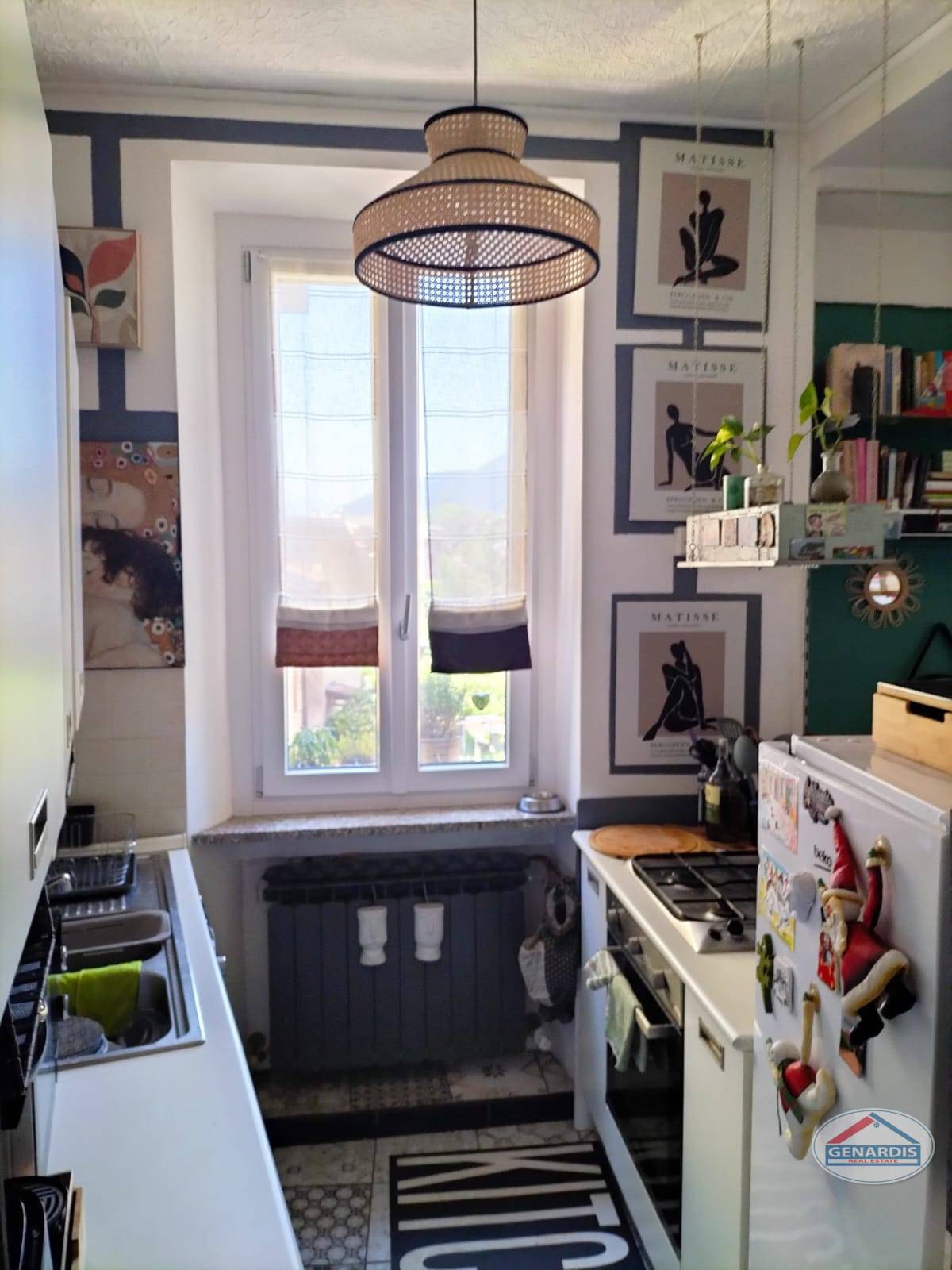 Kleine Küchenzeile mit Fenster und Dekowand